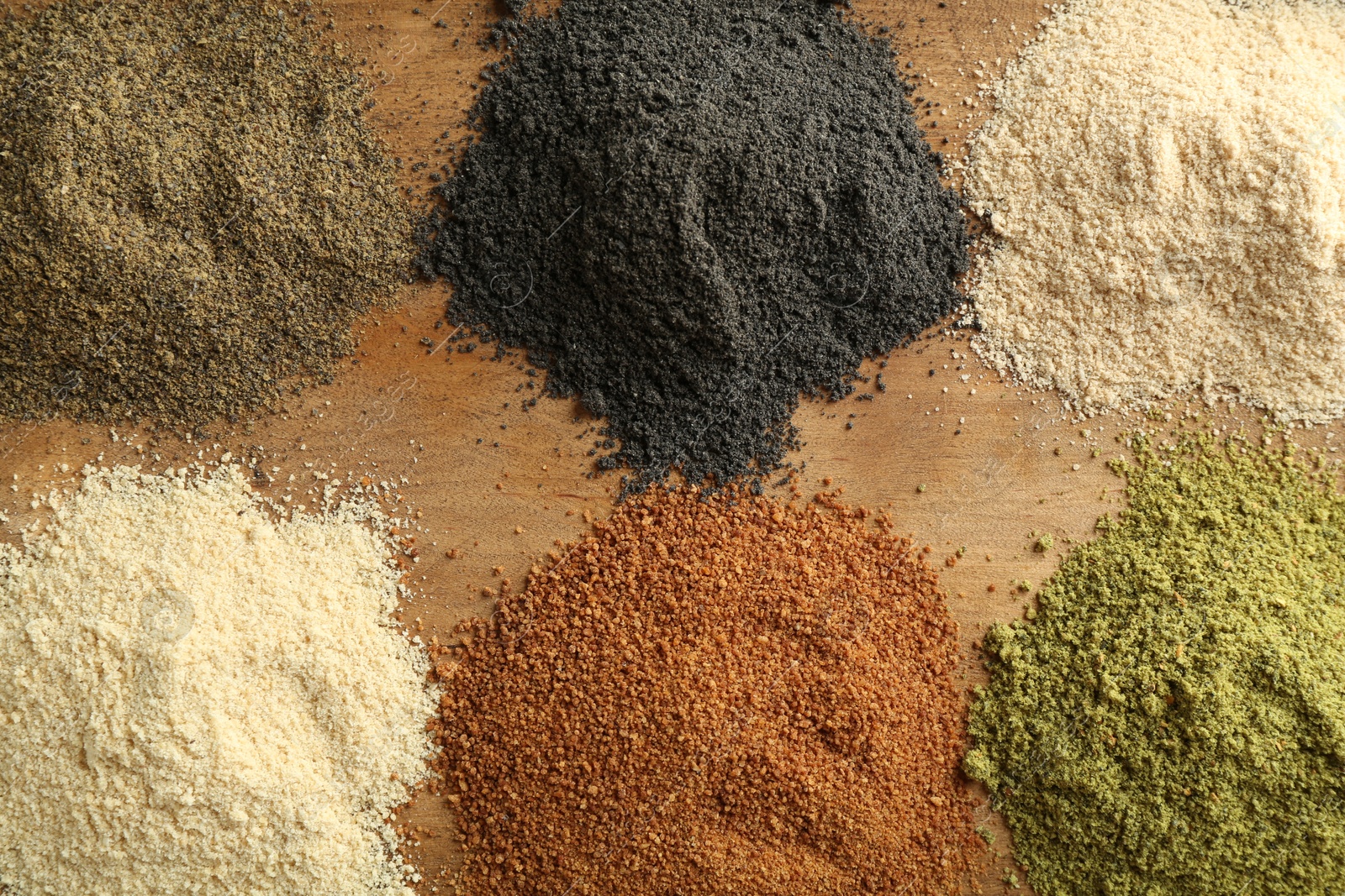 Photo of Different superfood powders on wooden table, flat lay