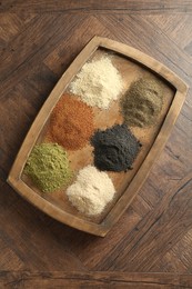 Different superfood powders on wooden table, top view