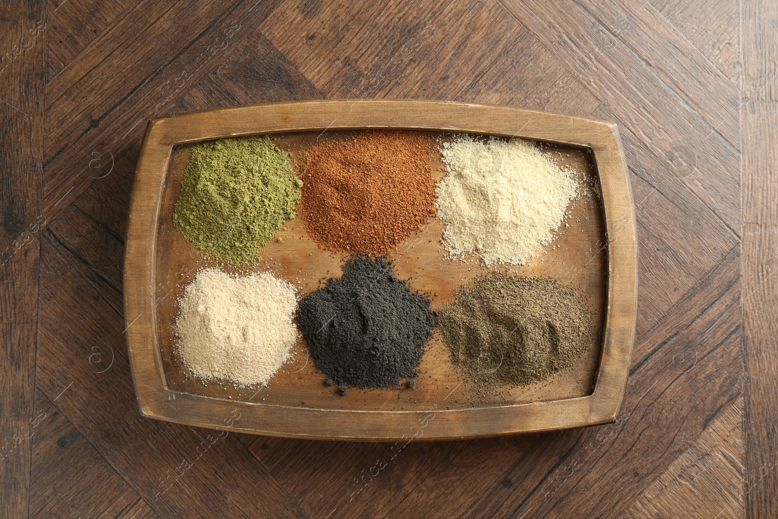 Photo of Different superfood powders on wooden table, top view