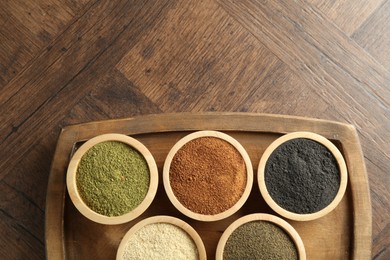 Photo of Different superfood powders in bowls on wooden table, top view