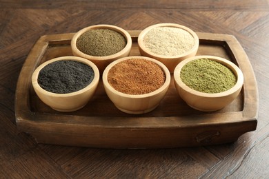 Different superfood powders in bowls on wooden table