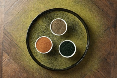 Photo of Different superfood powders in bowls on wooden table, top view