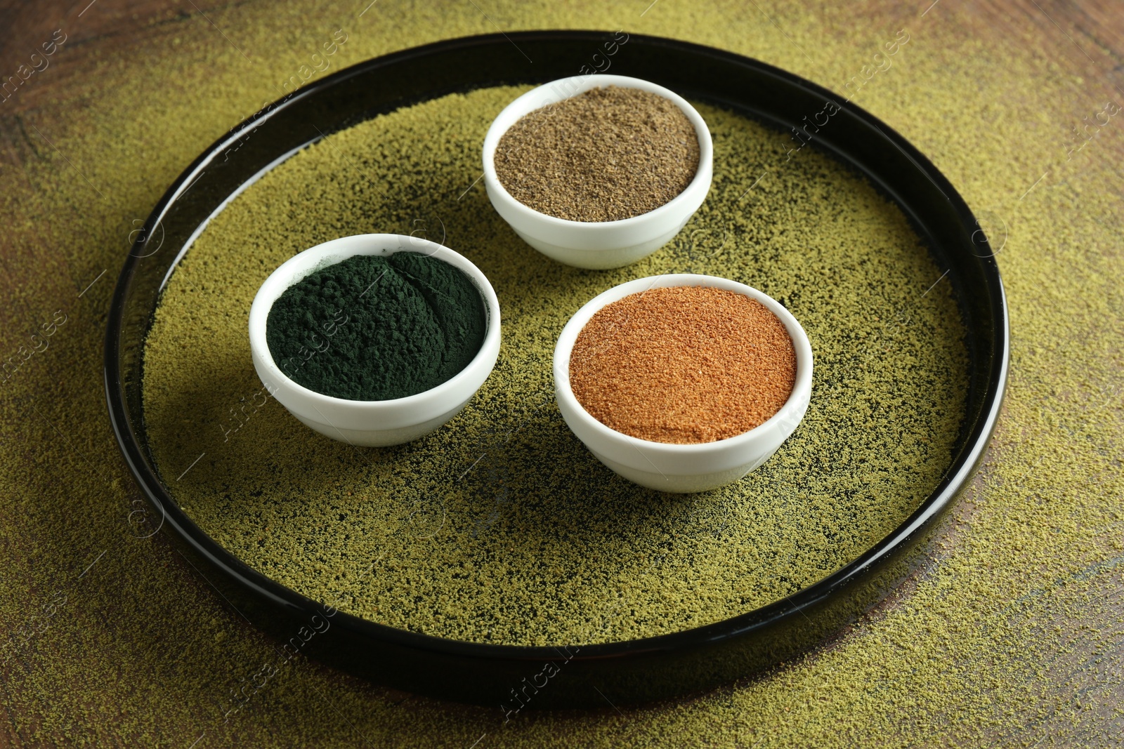 Photo of Different superfood powders in bowls on table