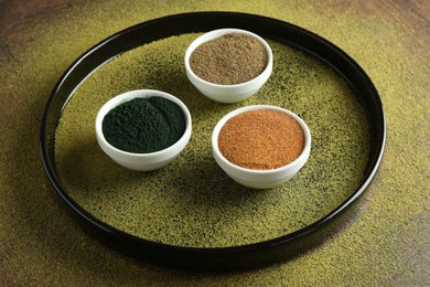 Photo of Different superfood powders in bowls on table