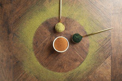 Photo of Different superfood powders on wooden table, flat lay