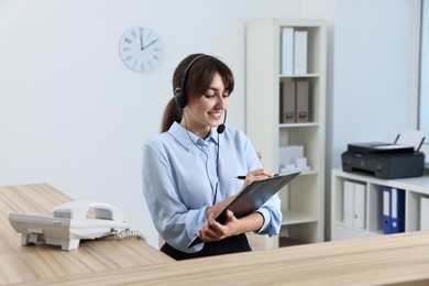 Photo of Professional receptionist working at wooden desk in office