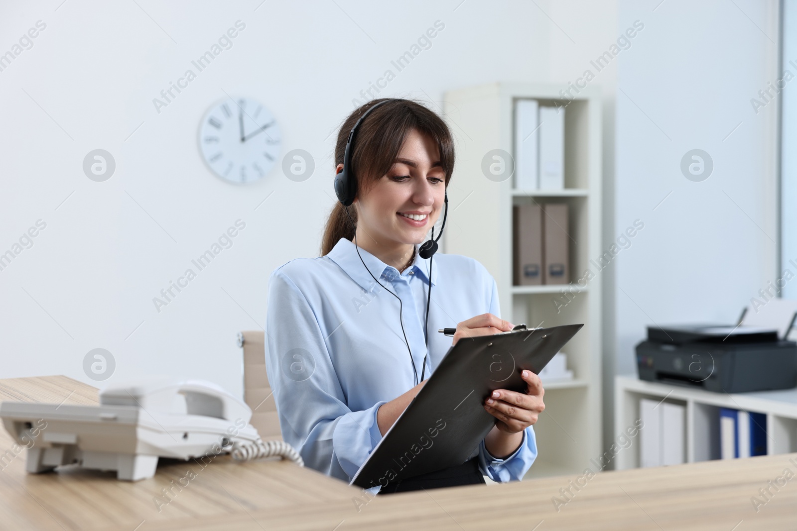 Photo of Professional receptionist working at wooden desk in office