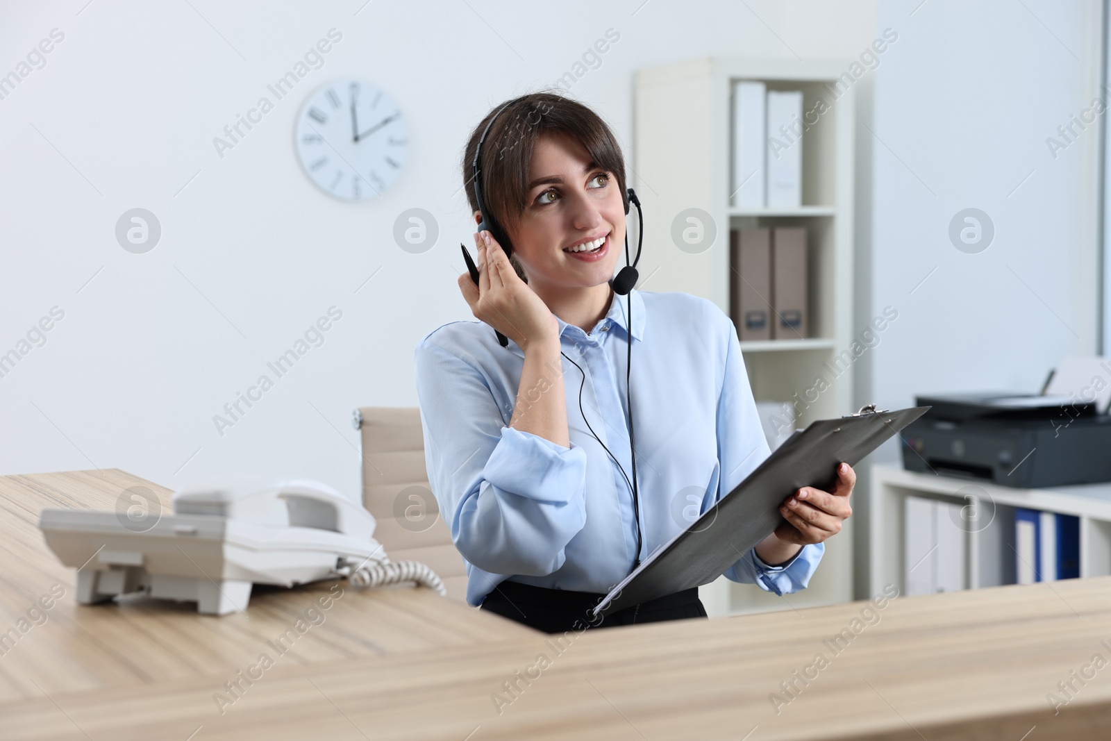 Photo of Professional receptionist working at wooden desk in office