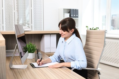 Photo of Professional receptionist working at wooden desk in office