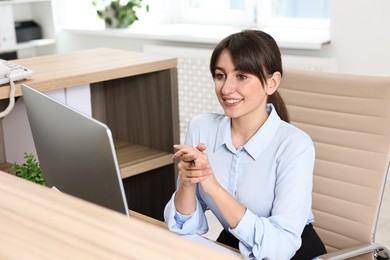 Photo of Professional receptionist working at wooden desk in office