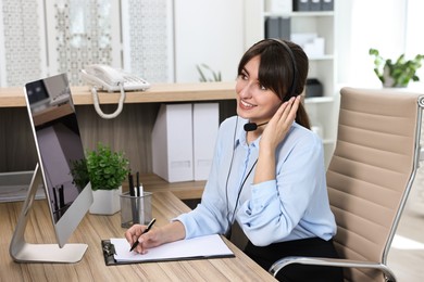 Professional receptionist talking on microphone in office