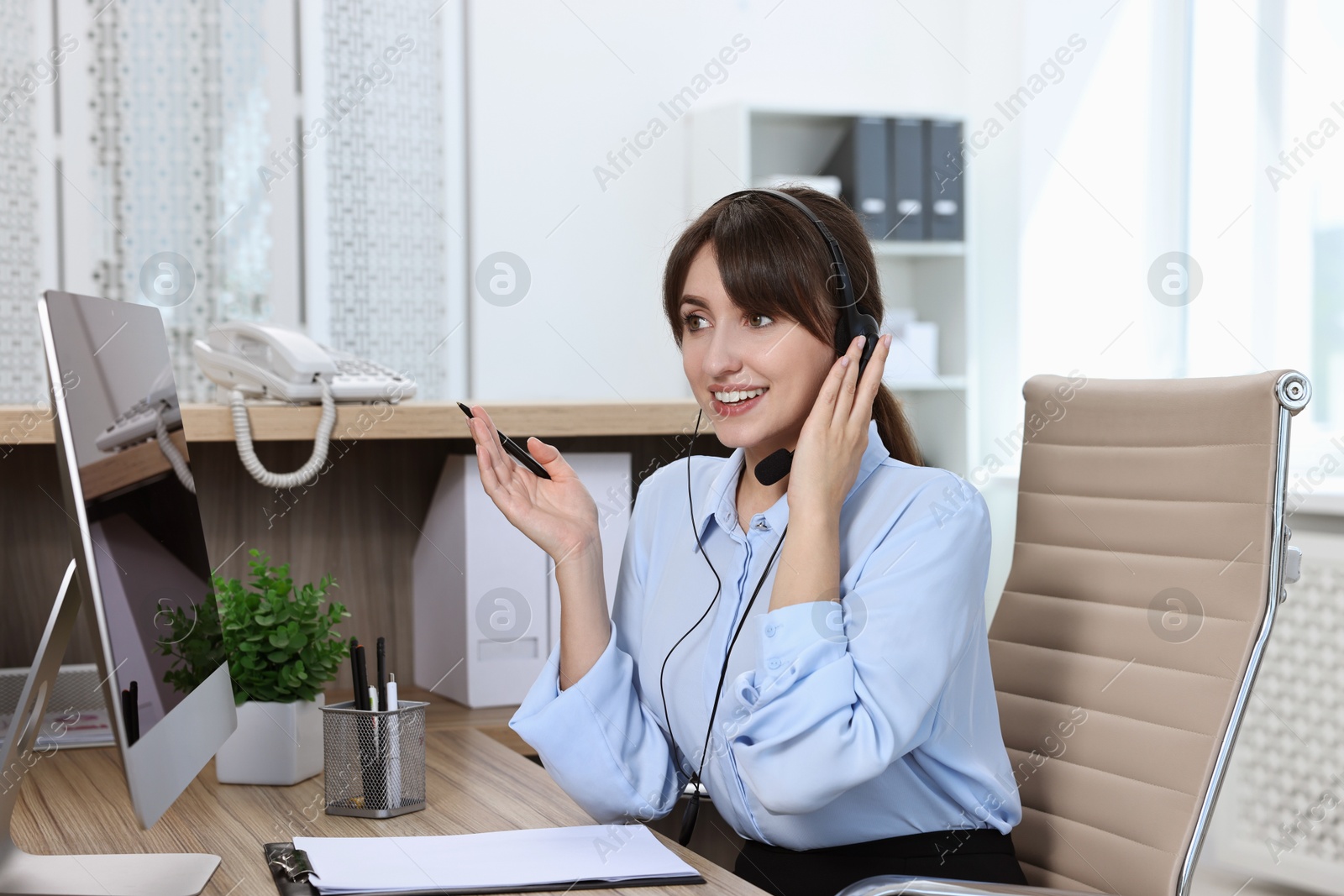 Photo of Professional receptionist talking on microphone in office