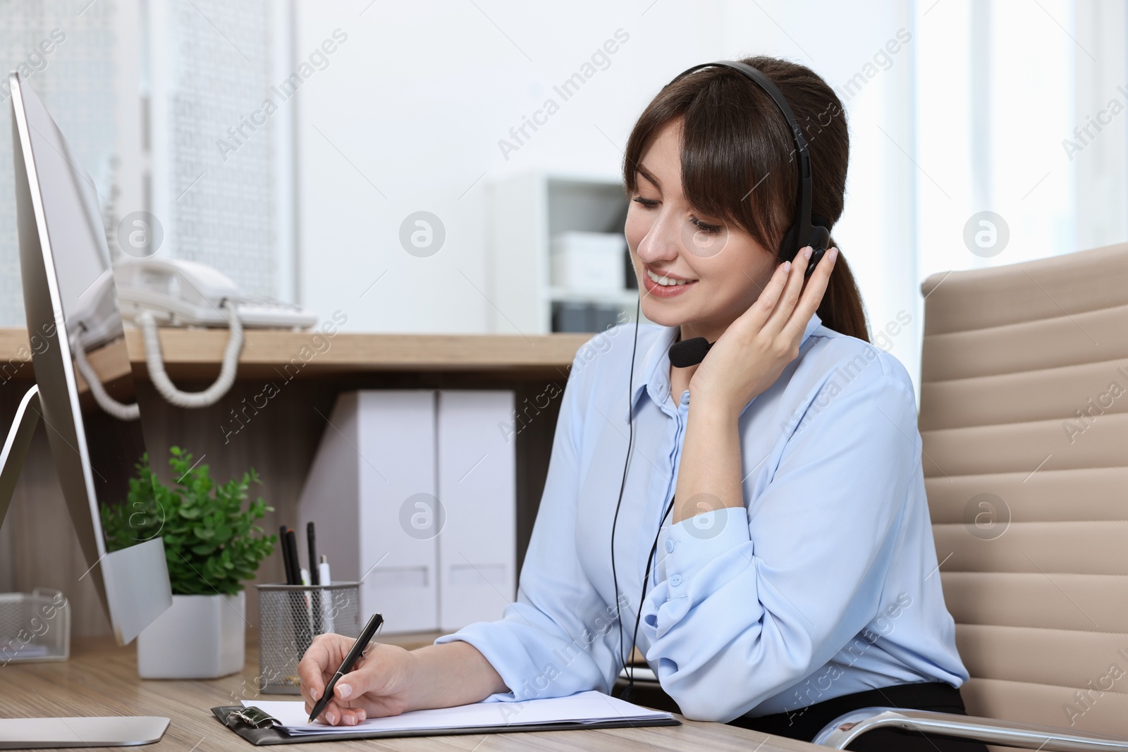 Photo of Professional receptionist talking on phone in office