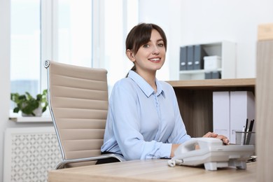 Photo of Portrait of receptionist at wooden desk in office