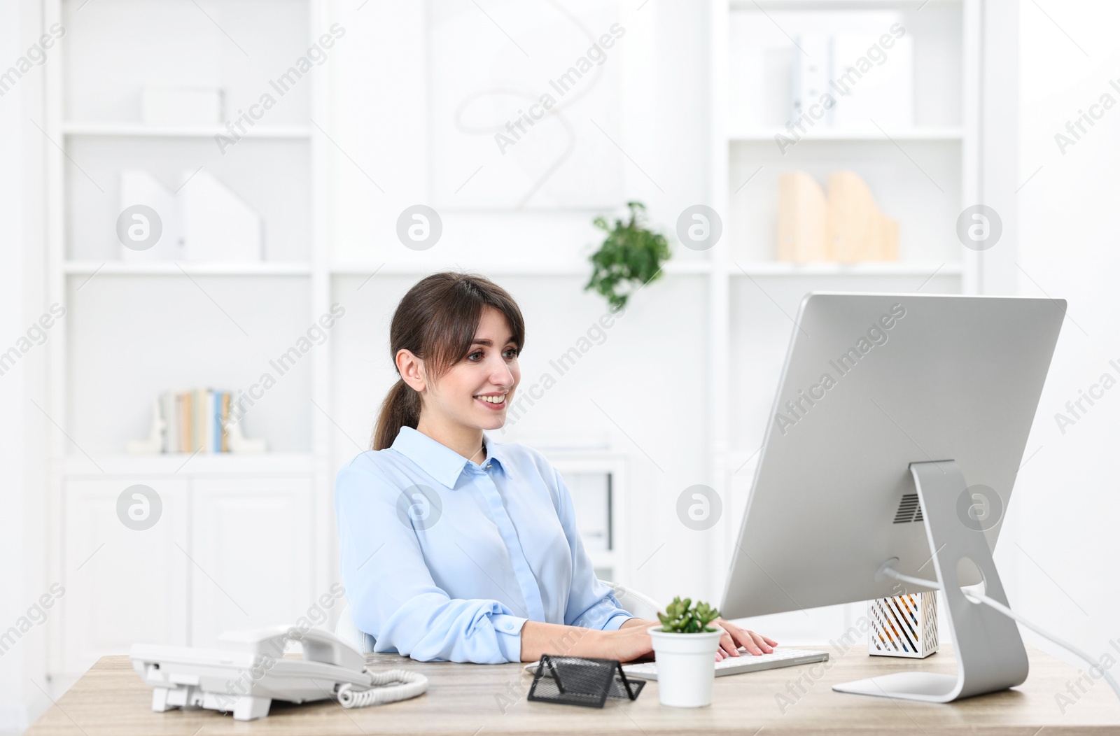 Photo of Professional receptionist working at wooden desk in office