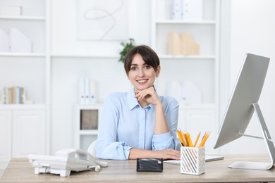 Photo of Portrait of receptionist at wooden desk in office