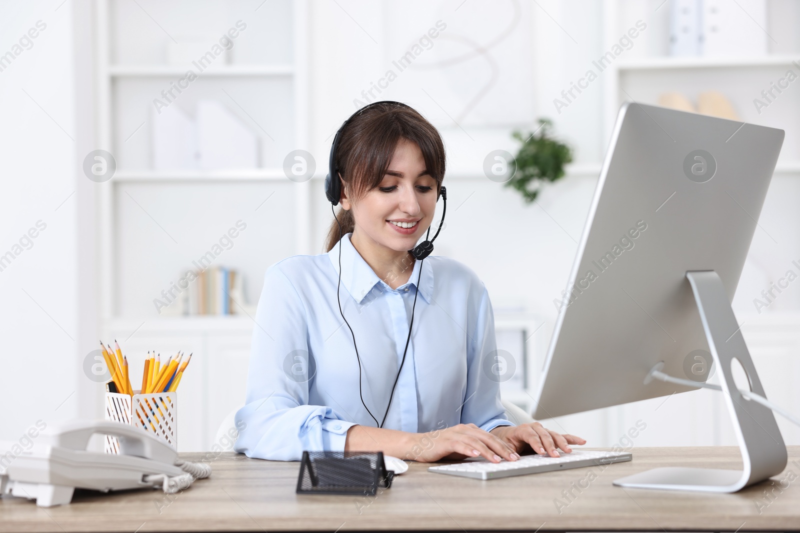 Photo of Professional receptionist working at wooden desk in office