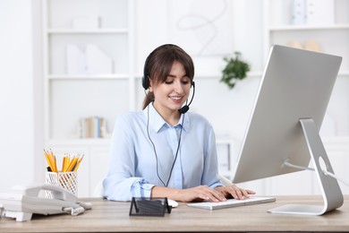 Professional receptionist working at wooden desk in office