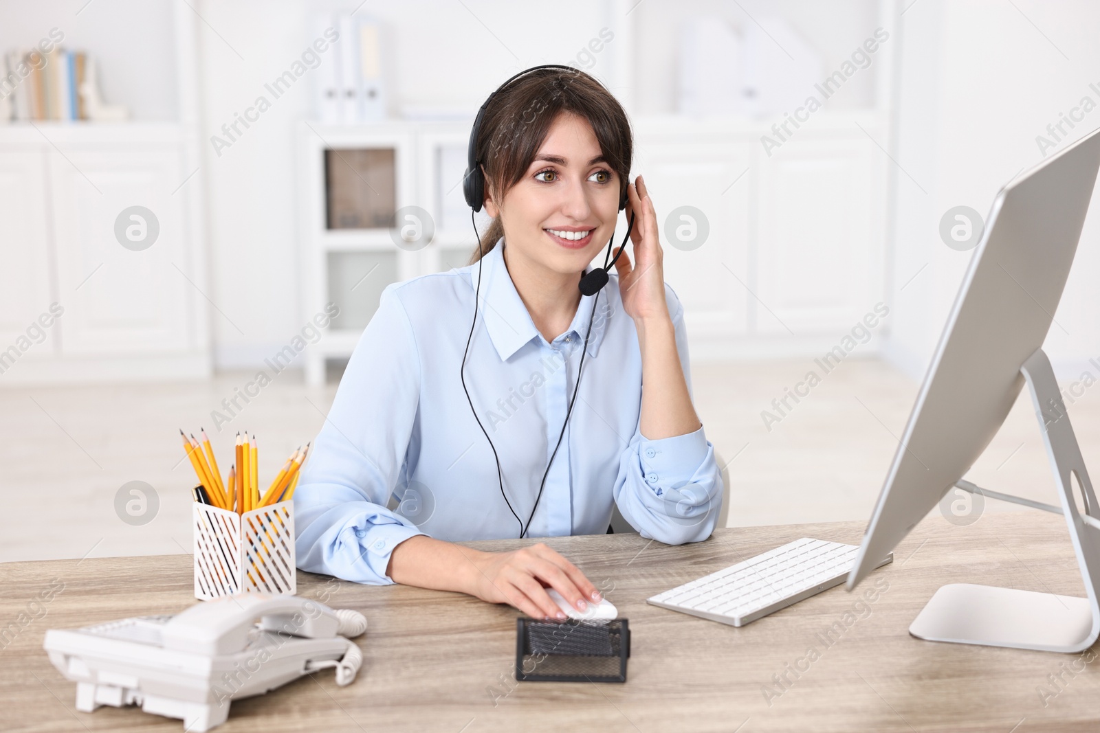 Photo of Professional receptionist working at wooden desk in office