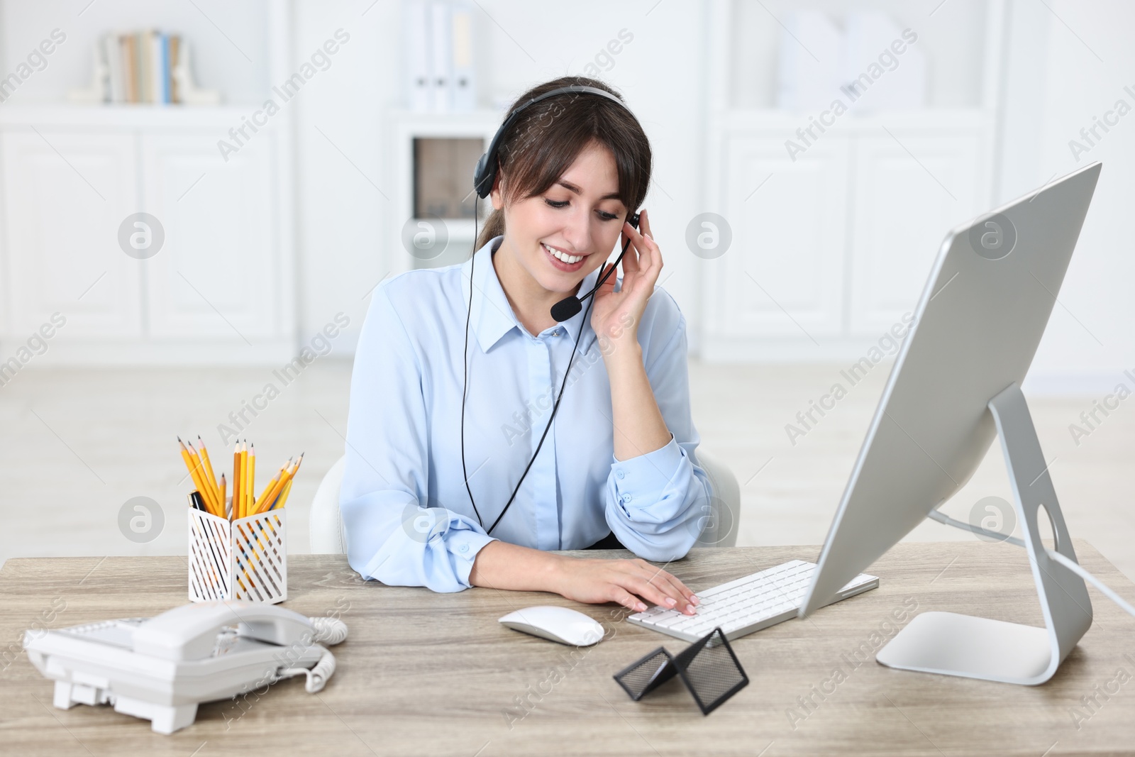 Photo of Professional receptionist working at wooden desk in office