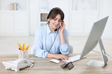 Professional receptionist working at wooden desk in office