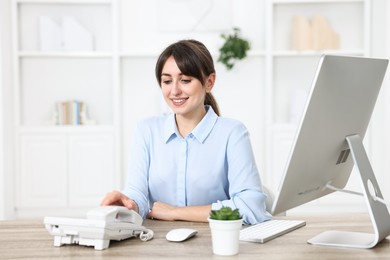 Professional receptionist working at wooden desk in office