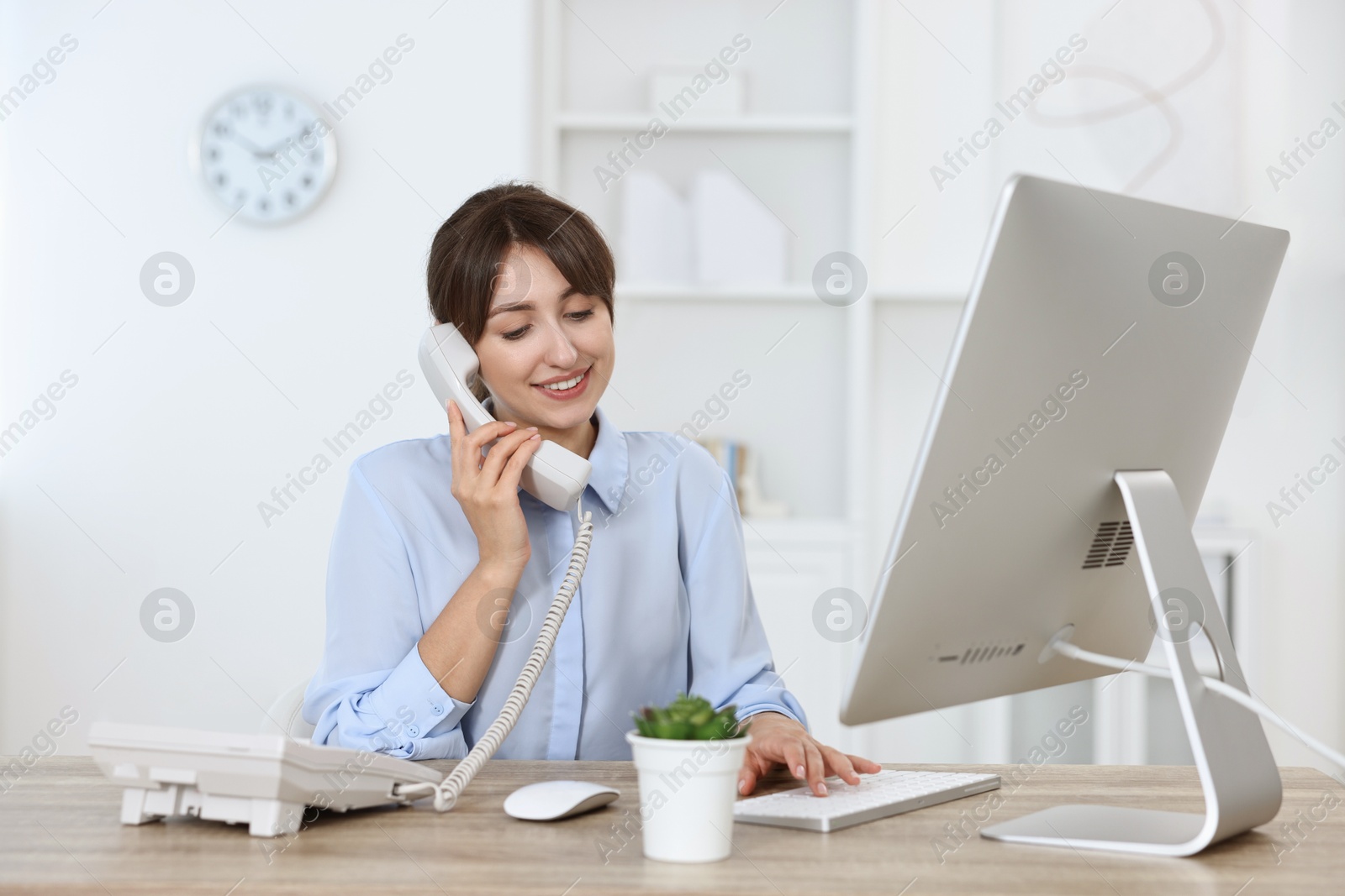 Photo of Portrait of receptionist at wooden desk in office