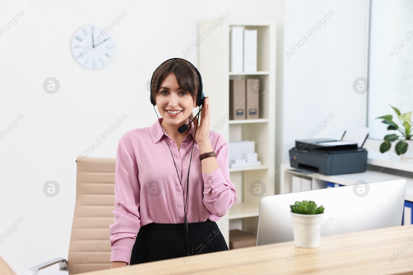 Photo of Professional receptionist working at wooden desk in office