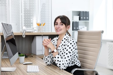 Photo of Portrait of receptionist at wooden desk in office