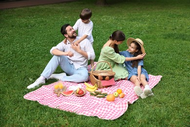 Happy family having picnic together in park