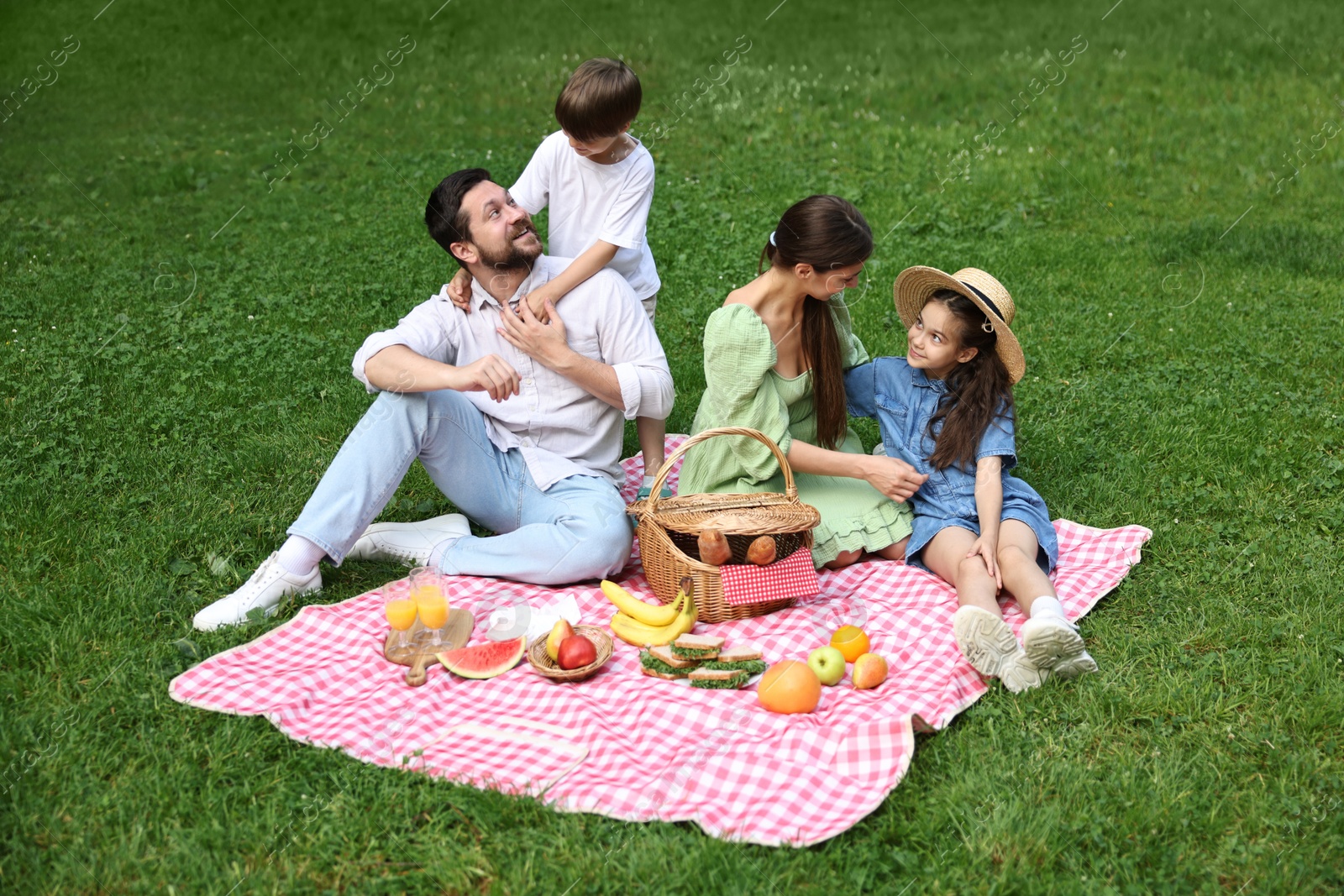 Photo of Happy family having picnic together in park