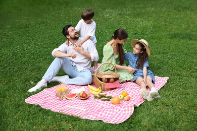 Happy family having picnic together in park