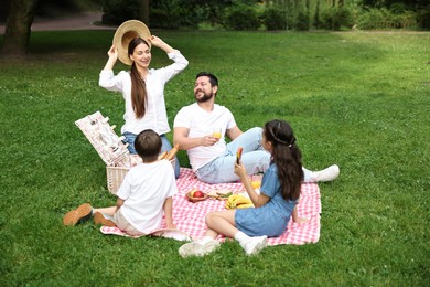 Photo of Happy family having picnic together in park