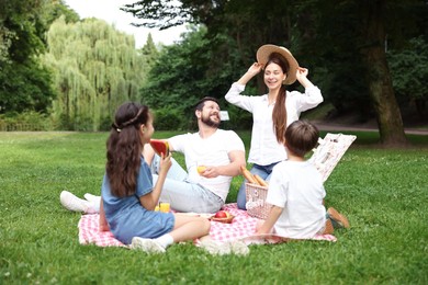 Happy family having picnic together in park