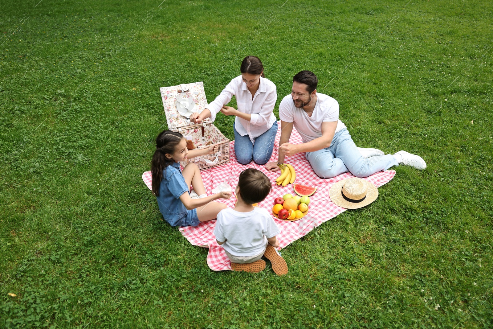 Photo of Family playing rock, paper and scissors during picnic outdoors