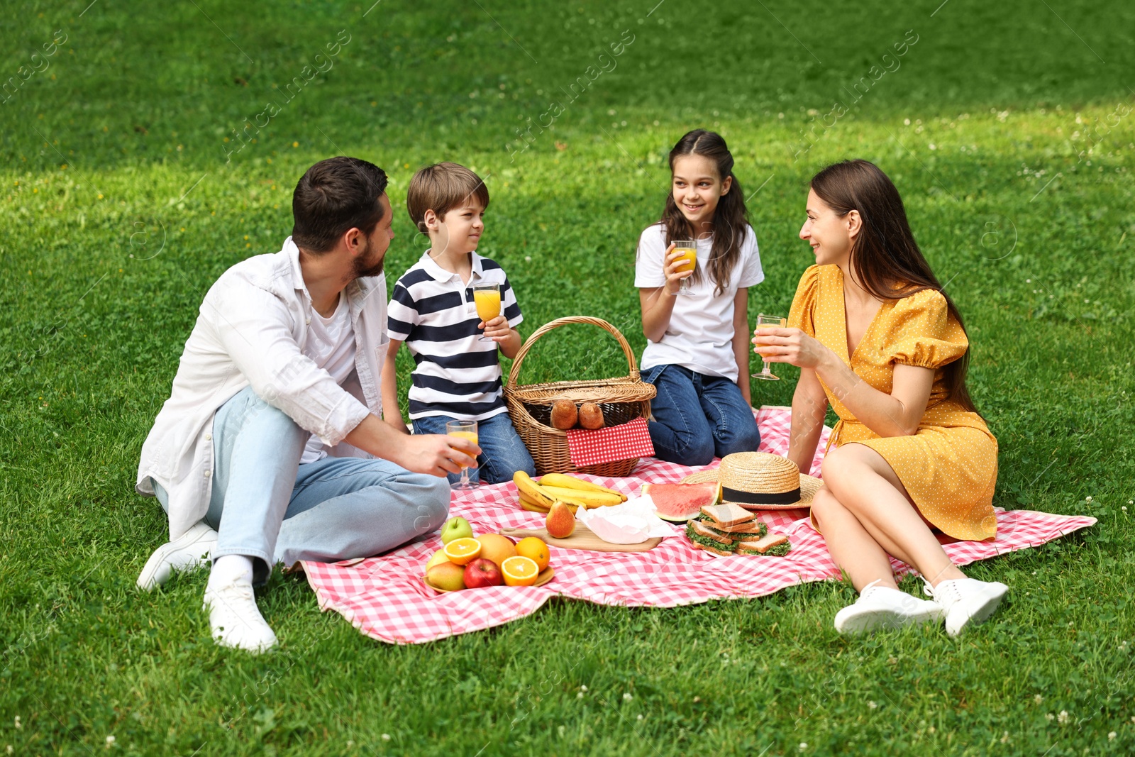 Photo of Family picnic. Parents and their children spending time together outdoors