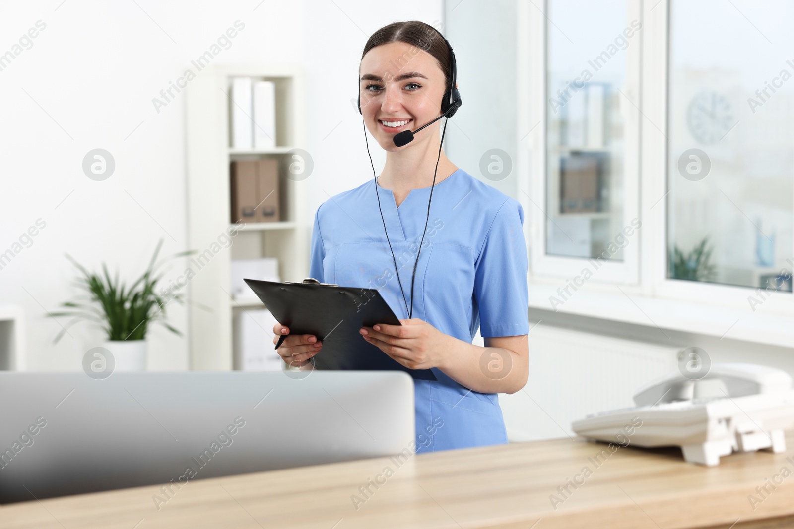 Photo of Professional receptionist working at wooden desk in hospital