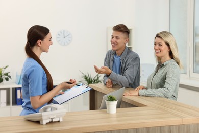 Professional receptionist working with patients in hospital