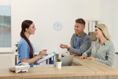 Professional receptionist working with patients in hospital