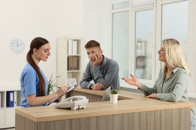 Professional receptionist working with patients in hospital