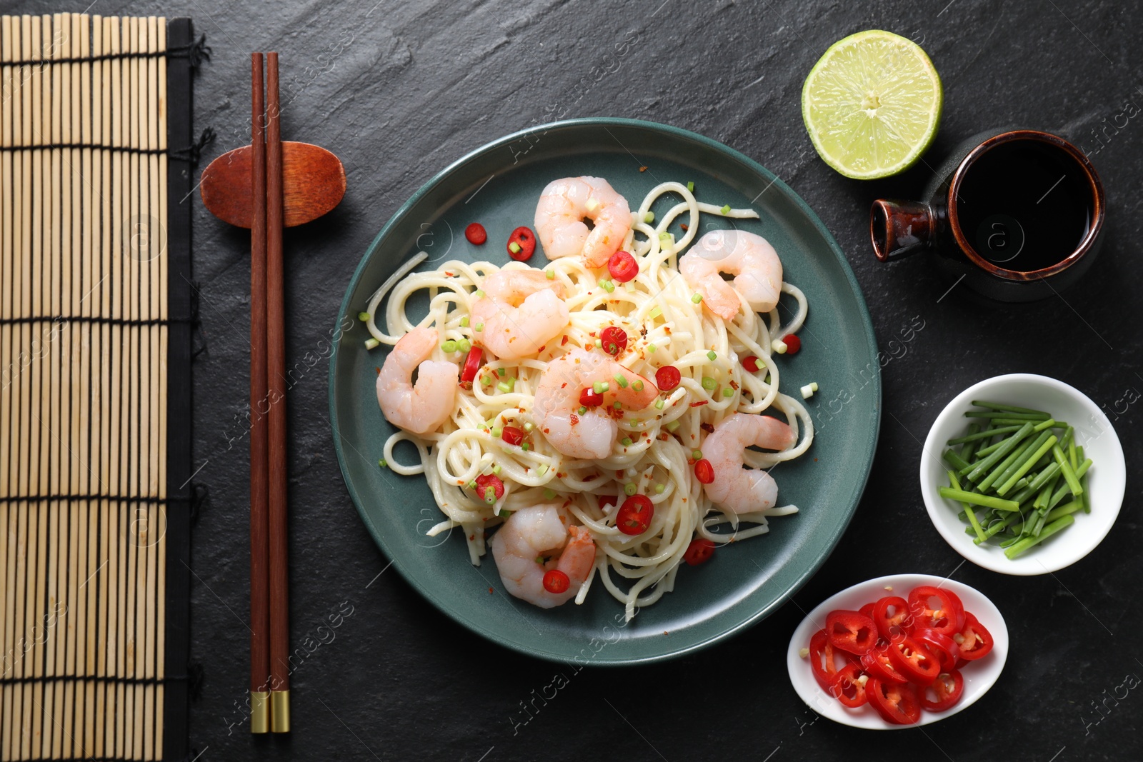 Photo of Delicious pasta with shrimps served on black table, top view