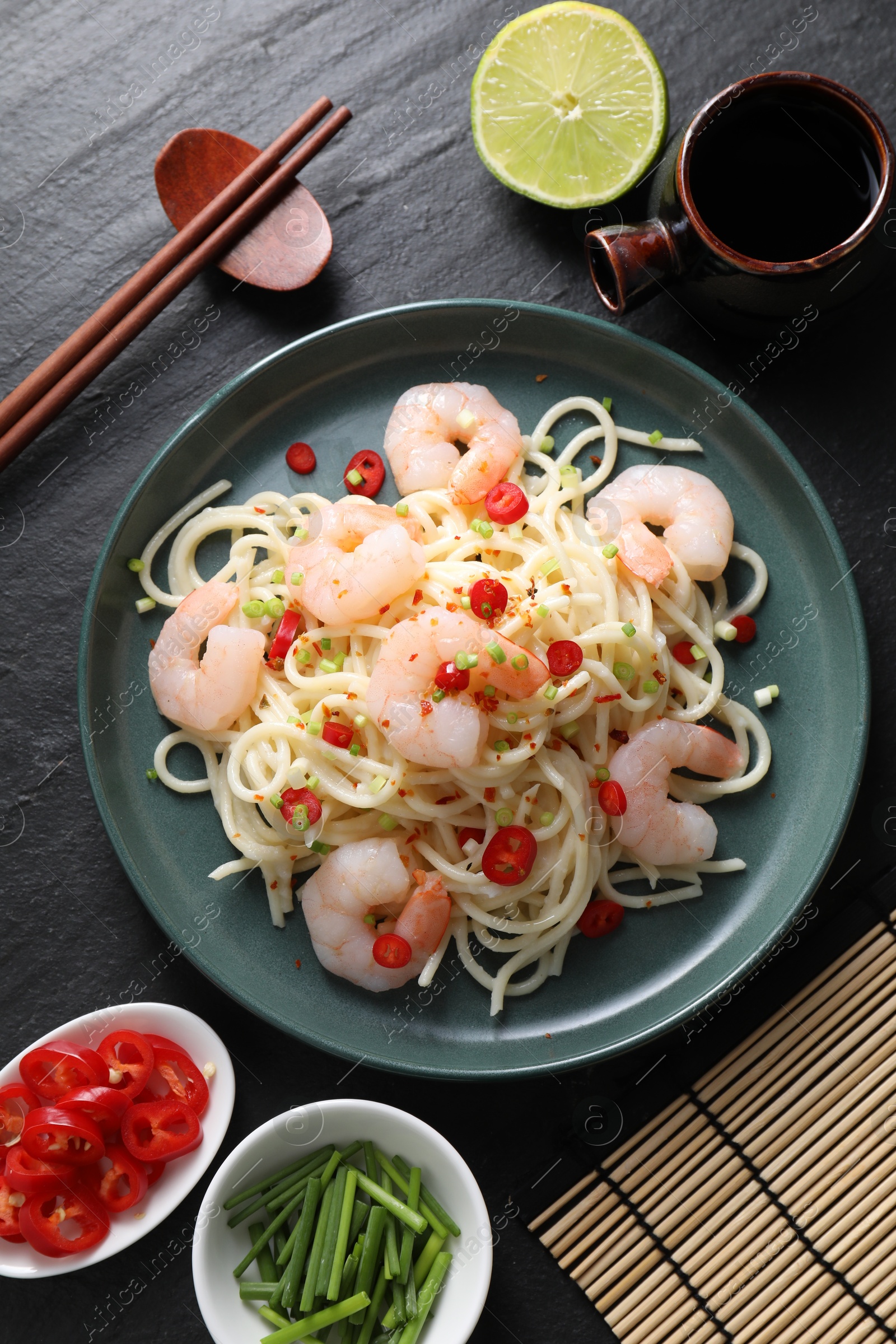 Photo of Delicious pasta with shrimps served on black table, top view