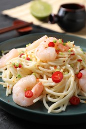 Photo of Delicious pasta with shrimps, green onion and chili pepper on black table, closeup