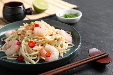 Photo of Delicious pasta with shrimps served on black table, closeup