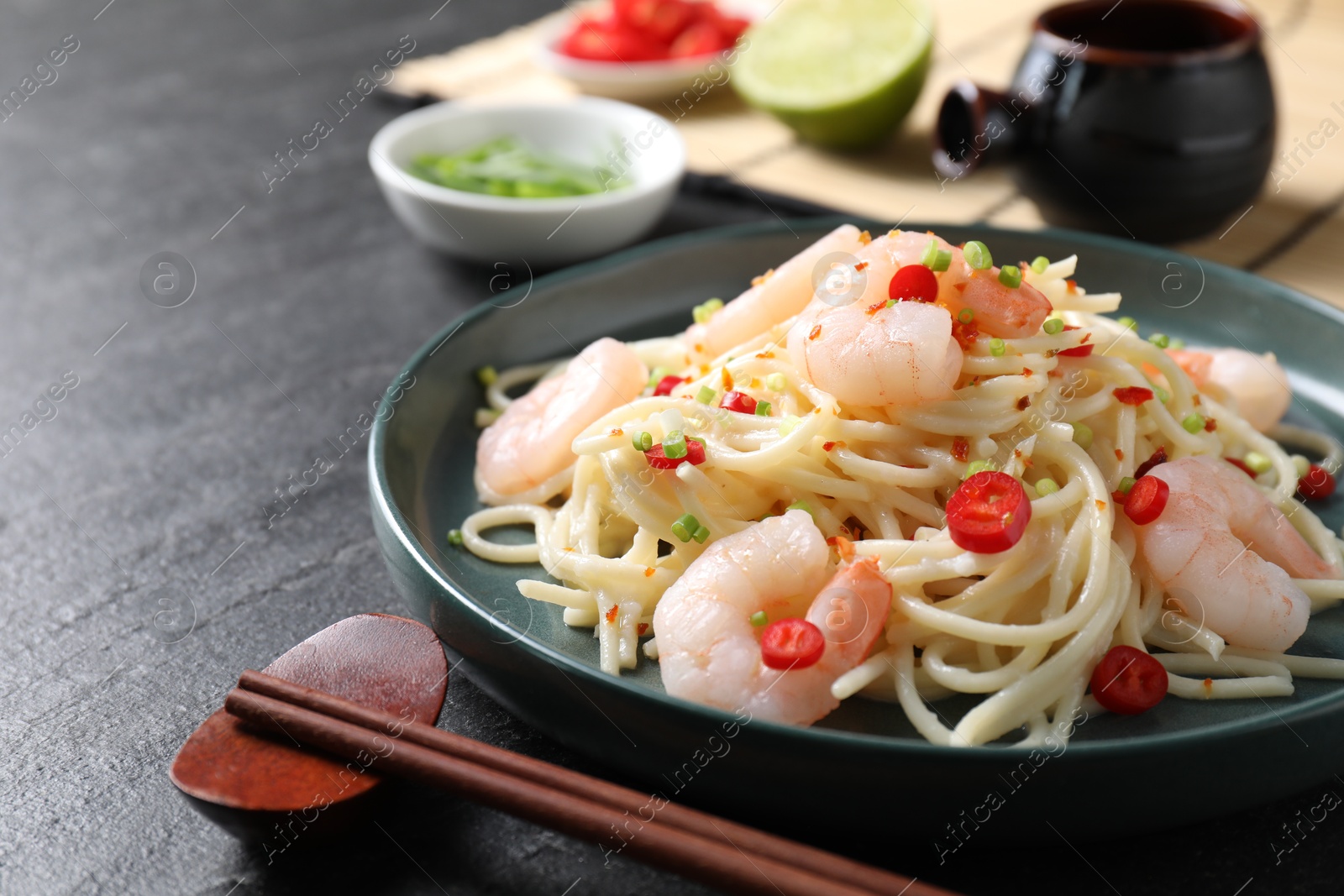 Photo of Delicious pasta with shrimps served on black table, closeup