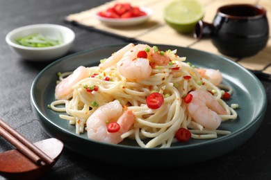 Photo of Delicious pasta with shrimps served on black table, closeup