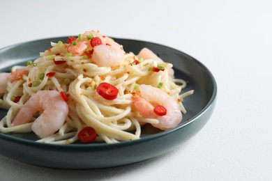 Photo of Delicious pasta with shrimps, green onion and chili pepper on white table, closeup