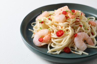 Photo of Delicious pasta with shrimps, green onion and chili pepper on white table, closeup