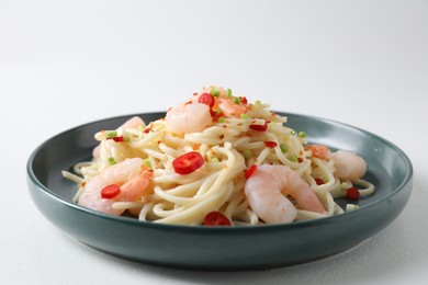 Photo of Delicious pasta with shrimps, green onion and chili pepper on white table, closeup