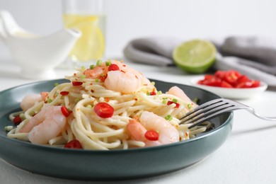 Photo of Delicious pasta with shrimps, green onion and chili pepper on white table, closeup